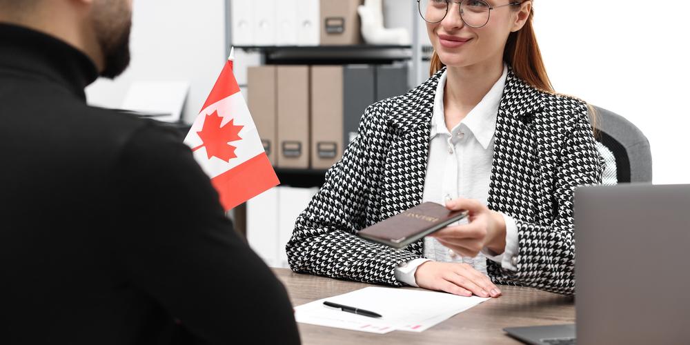 Poignée de main entre deux gens d'affaires avec un horizon de ville canadienne en arrière-plan.